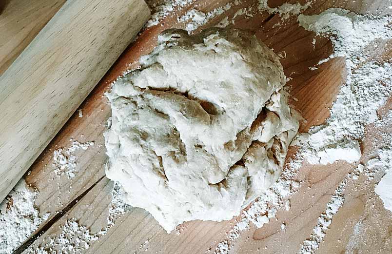 A photo of a ball of dough on a kneeding board