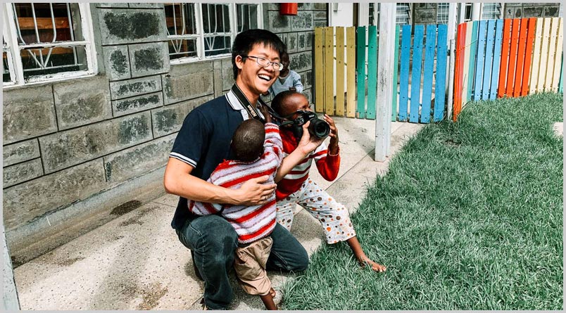 Kenya: a volunteer corralling two toddlers at the Africa Gospel Church Baby Center A photo of a volunteer corralling two toddlers at the Africa Gospel Church Baby Center.