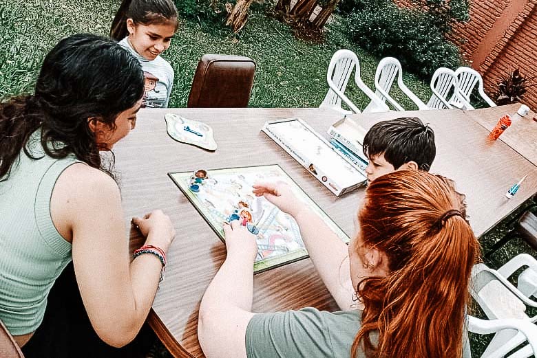 Two adults and two elementary aged children playing child's board game