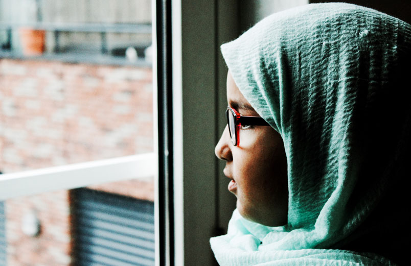 A woman looking out a of a window.