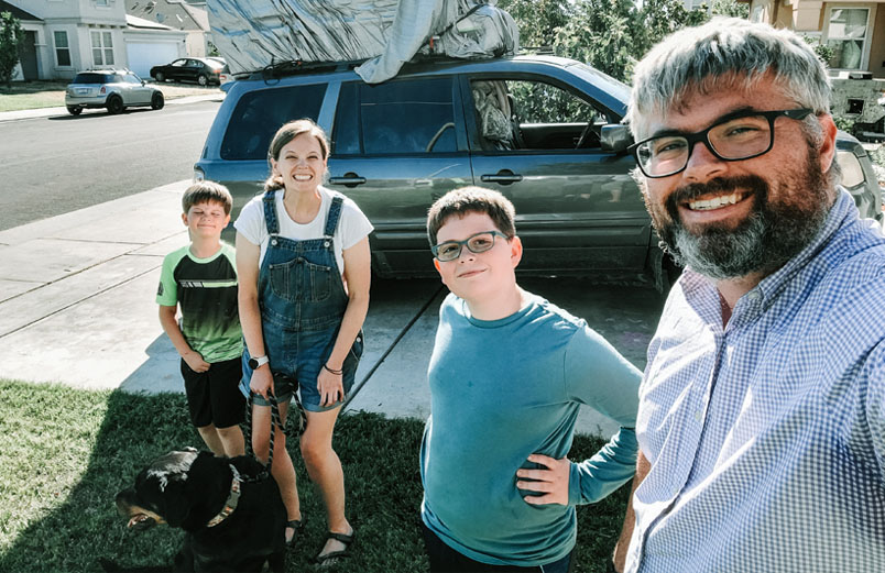 At home in Stockton A husband and wife pose with their two boys and their dog in front of their van in the driveway.