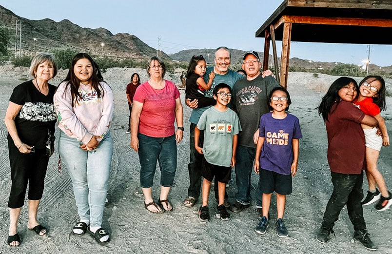 A group of children walks outside with a handful of missionaries.