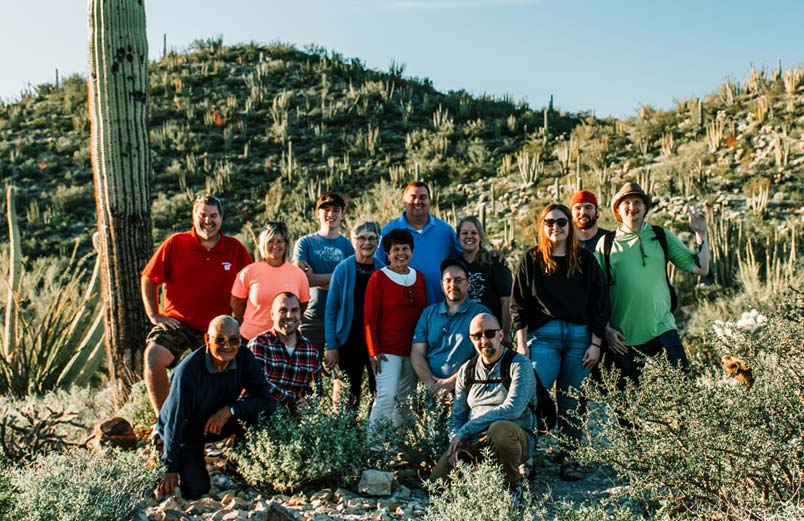 The team members posing for a picture among the Saguaro cacti