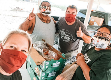 Darin and Laura Arnott, along with two others, wearing masks and collecting food to give away