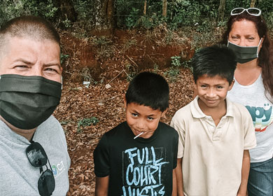 Steve and Kelley wearing masks and posing with two of their students