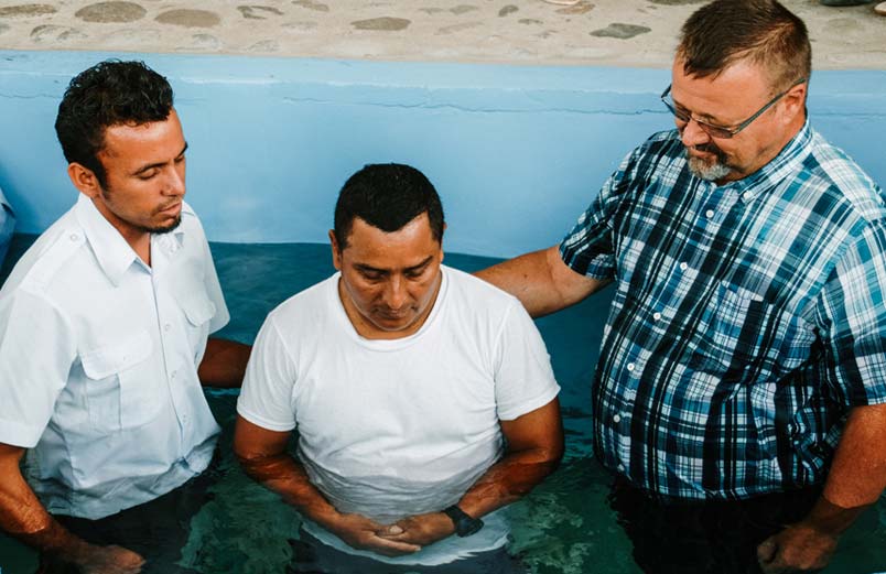 Addis and Larry baptizing a third man