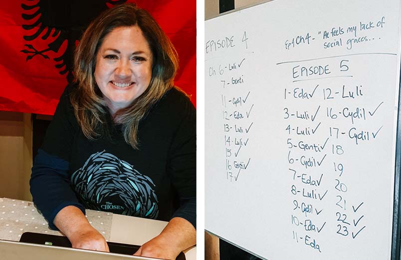 A smiling Cydil Waggoner with her laptop sitting in front of the Albanian flag beside a whiteboard with checklists