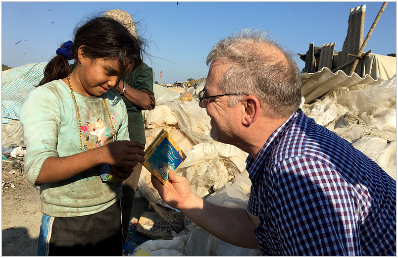 Gabriella, showing David Hawk a book she found in the dump