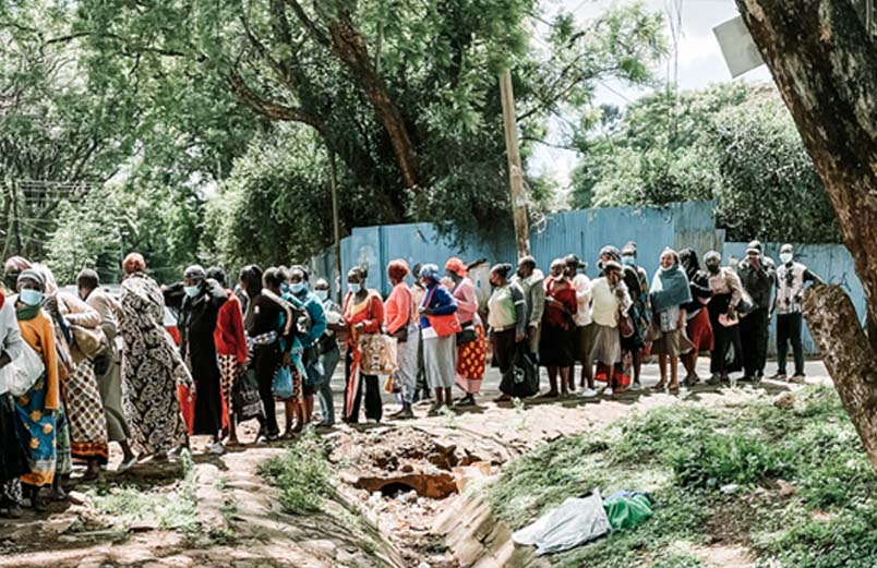 A long line of women standing along the side of a road.
