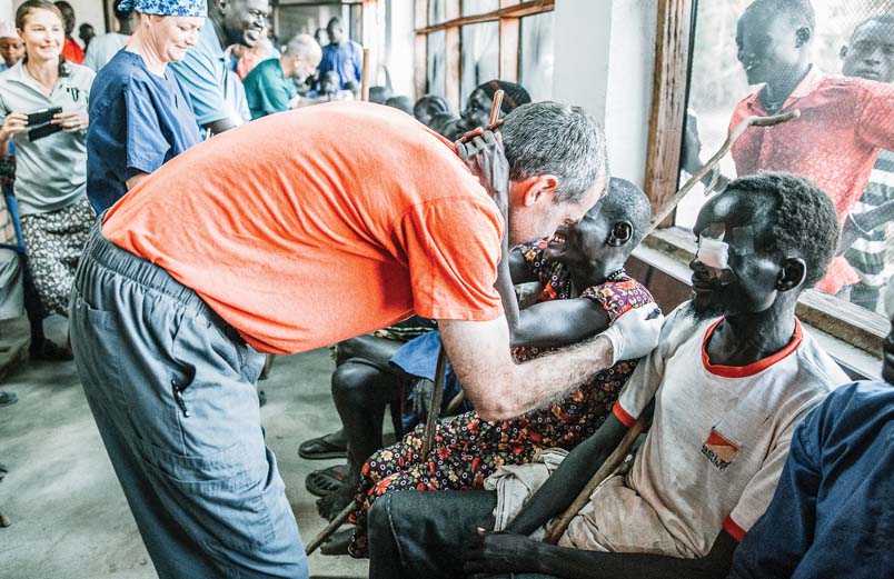 A row of patients beginning to smile as the bandages are removed from their eyes