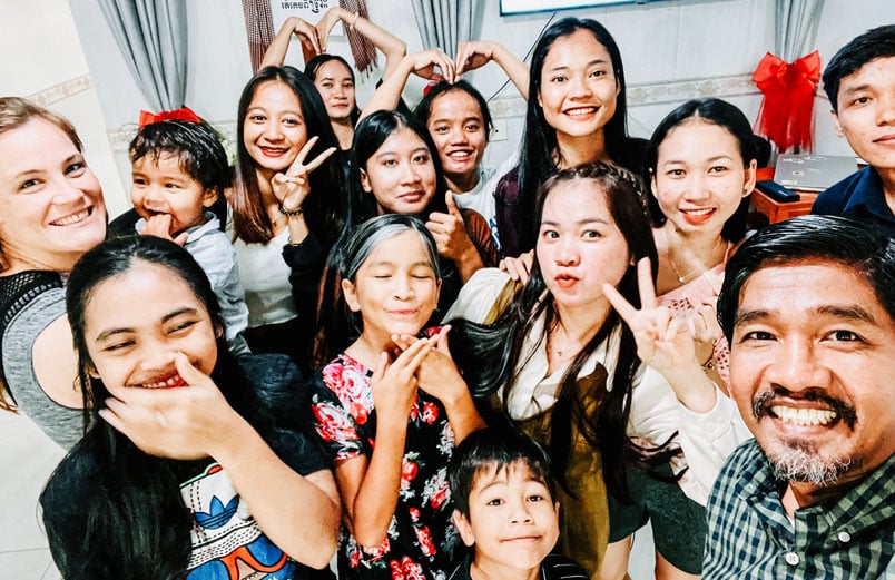 A group of smiling young people and two adults